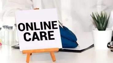 Hand drawing ONLINE CARE inscription with white chalk on blackboard medical concept